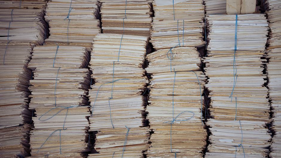 積み上げられた大量の紙の束を正面から撮影したイメージ画像