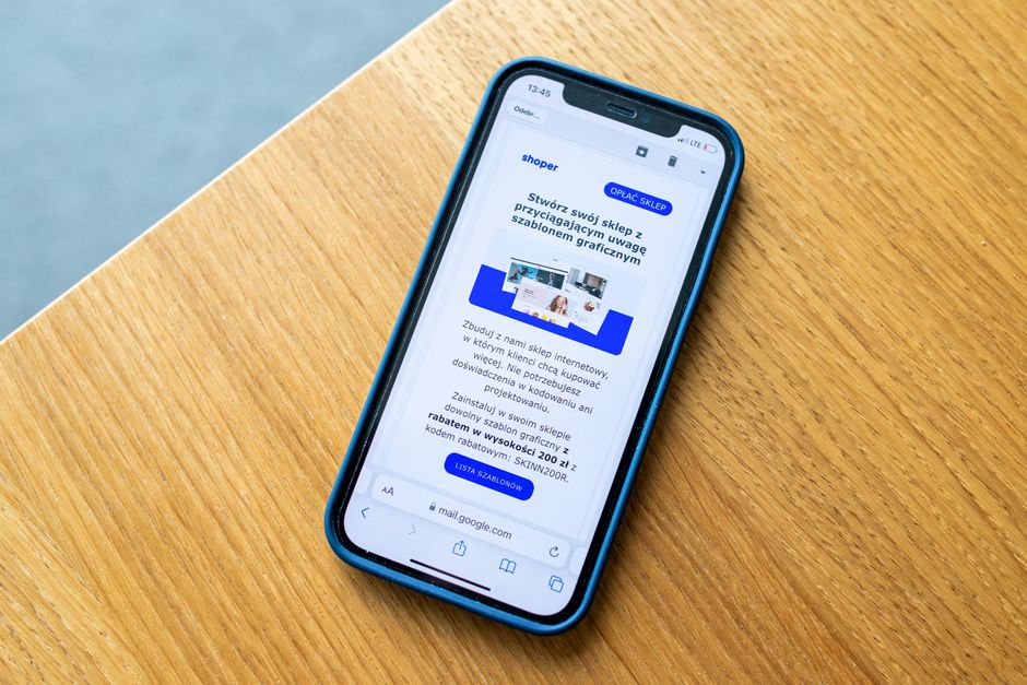 木の机に置かれたスマートフォンに、オンラインショップの商品画面が表示されているイメージ画像